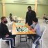 Profesor enseñando a juagar ajedrez a niño y adulto mayor